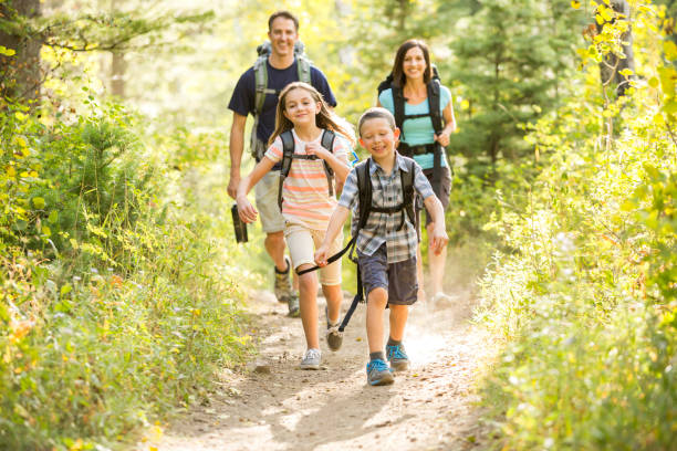 Famille avec parents et deux enfants en train de se promener en montagne