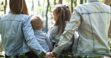 Famille de dos assise dans une forêt