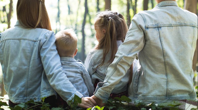 Famille de dos assise dans une forêt