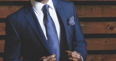 zoom sur le buste d'un homme qui porte un costume bleu marine avec une chemise blanche et une cravate bleu marine